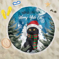 Blue round beach blanket with fringe edge, black cat in red Santa hat among snowy trees