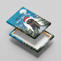 Blue canvas wall art on easel, black cat in Santa hat and striped scarf over snowy trees
