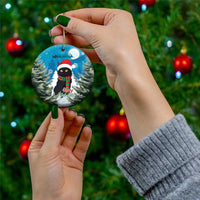 Blue round ceramic Christmas ornament with black cat in Santa hat and red plaid scarf