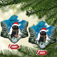 Pair of blue tree-shaped ornaments with black cat in Santa hat and red plaid scarf