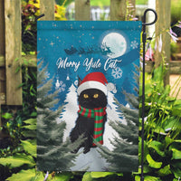 Blue garden flag with black cat in Santa hat and striped scarf over pine trees