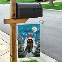 Blue Christmas garden flag hanging from a wooden post with black cat in Santa hat