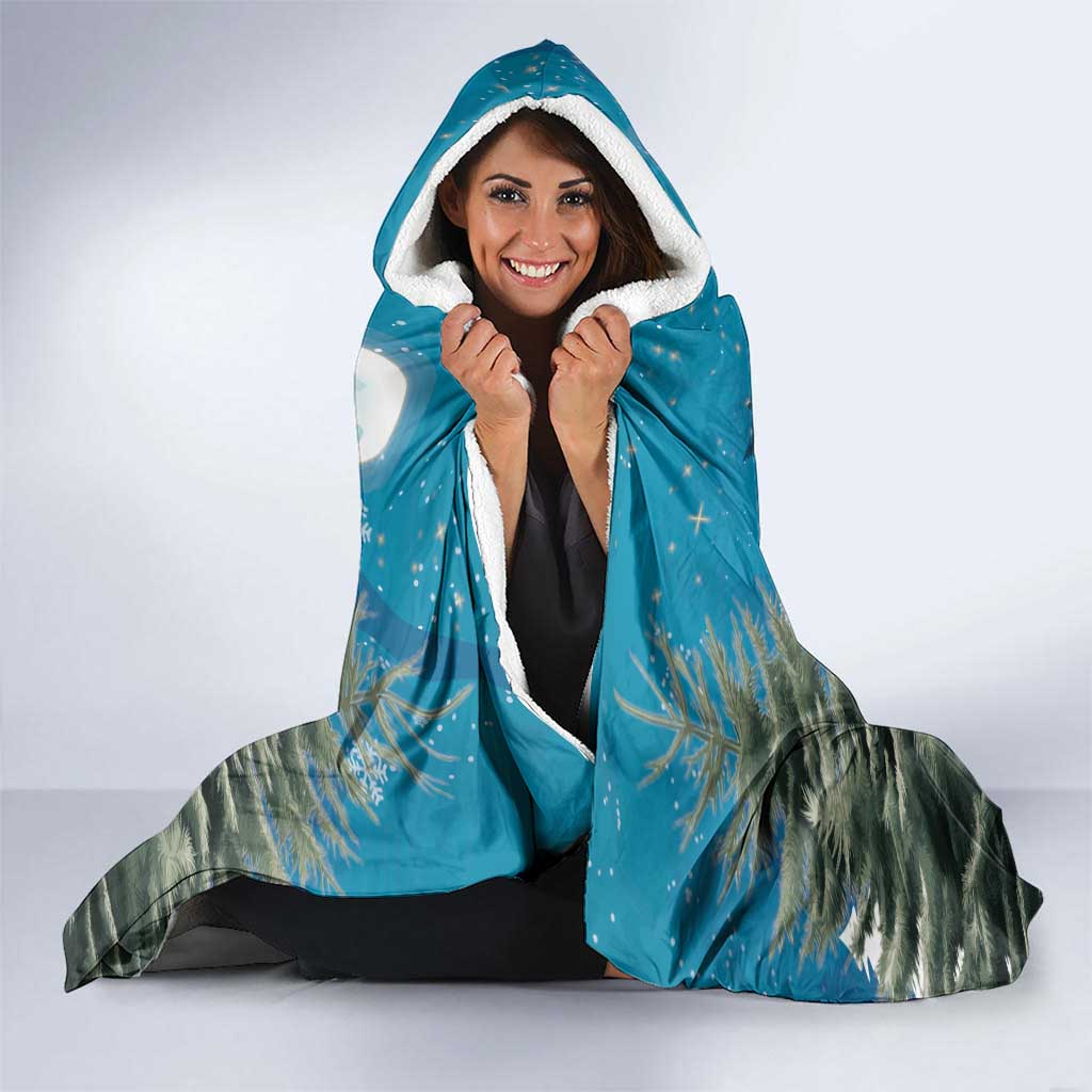 Blue hooded throw blanket with white-lined hood; woman holds it closed, cat design