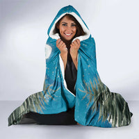 Blue hooded throw blanket with white-lined hood; woman holds it closed, cat design