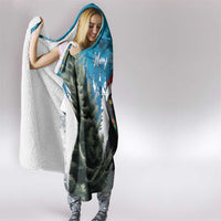 Blue hooded Christmas blanket with cat scene; woman wearing it with hood up