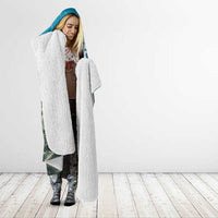 Blue hooded Christmas blanket worn by woman; long blanket with sherpa-style hood lining