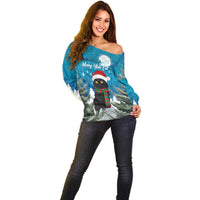 Blue off-shoulder sweater with front holiday cat in Santa hat, winter landscape print