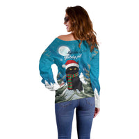 Blue off-shoulder sweater with rear holiday cat graphic, snow trees and moon print