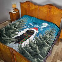 Quilt blanket on a bed: blue pine scene with black cat in scarf and Merry Yule Cat.