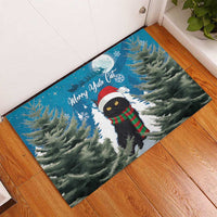 Blue rubber Christmas doormat with black cat in Santa hat and red-green scarf, snowy pine