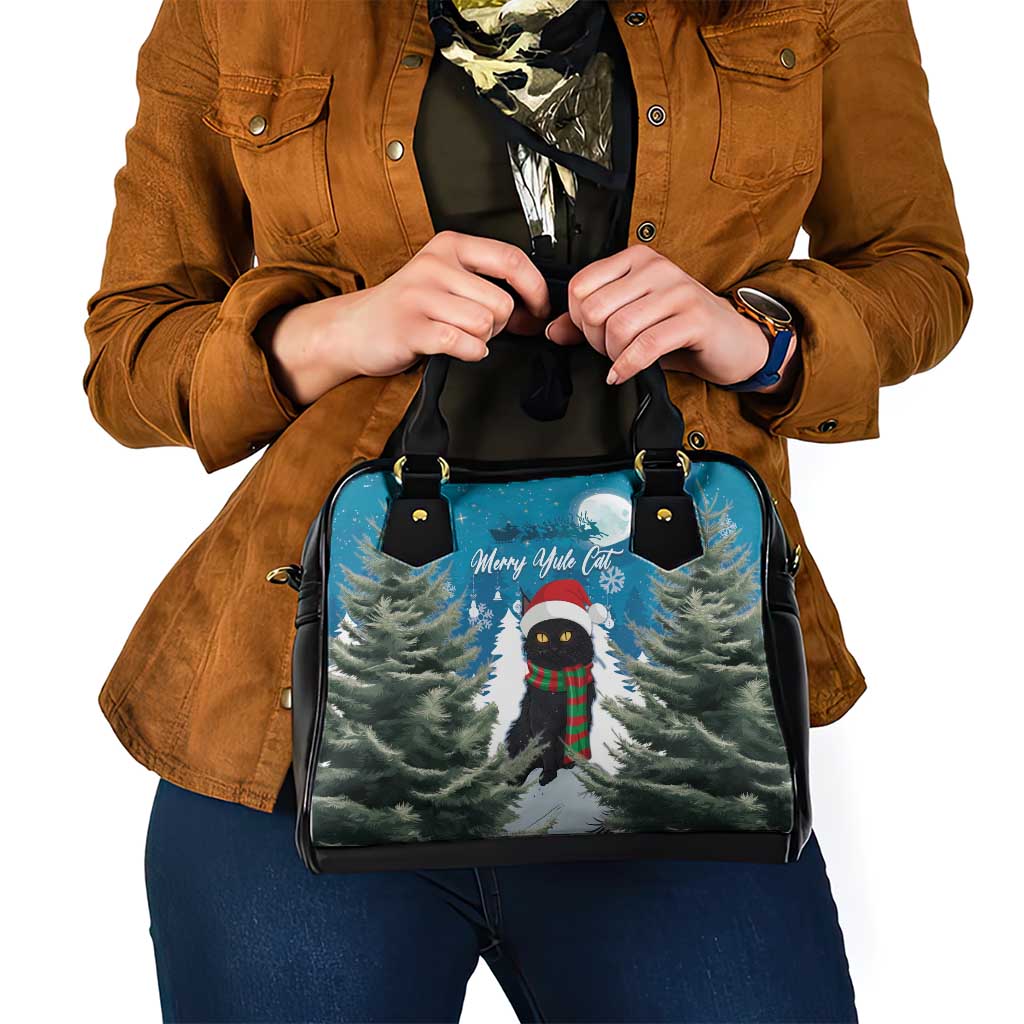 Blue handbag with black handles and front Merry Yule cat and tree scene design.