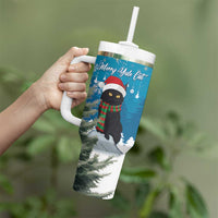 Blue Christmas tumbler held in hand with handle, straw lid, and cat holiday artwork