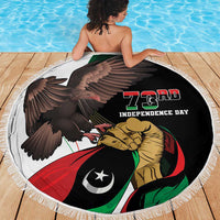 Round beach blanket with black graphic of eagle, lion, and flag colors, white fringed edge
