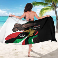 Black printed sarong with large eagle and Libya flag graphic, draped on beach