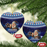 Pair of blue ceramic heart ornaments with gnome and house artwork, hanging on gold cords