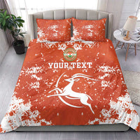 Orange graphic duvet and two pillows with white splatter, circular emblem and 'YOURTEXT' text