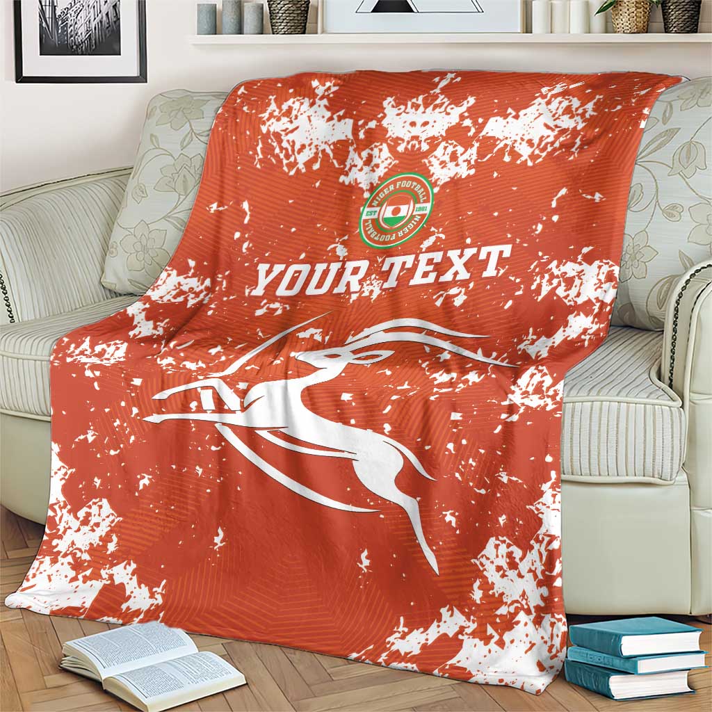 Orange football blanket with white splatter print, crest emblem and “YOUR TEXT”