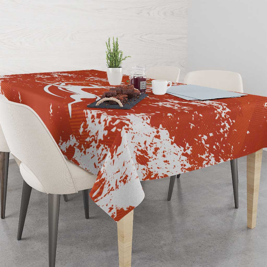 Orange football tablecloth with white splatter print over dining table and chairs