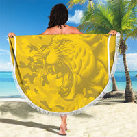 Yellow round beach blanket with white fringe and lion graphic, displayed on sand