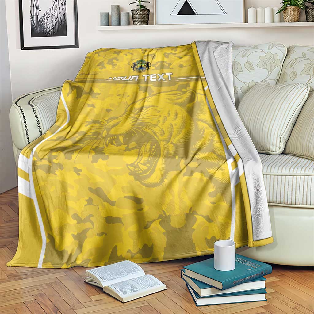 Custom yellow football blanket draped on sofa with lion graphic and 'YOUR TEXT' strip