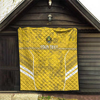 Yellow football quilt hanging indoors with custom text and white field line accents, quilted