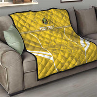 Yellow football quilt draped on gray sofa with white field lines and custom text, quilted