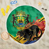 Green round beach blanket with white fringe and Gabon crest with black panther graphic
