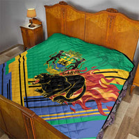 Green quilted blanket on bed with Gabon crest, black panther, and flame stripe motif