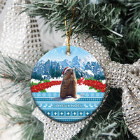 Round ceramic Christmas ornament with marmot, snowy mountains, and JOYEUX NOEL text.