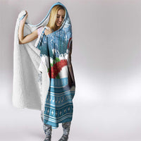 Hooded blanket with blue outer print and white sherpa lining, worn and wrapped around woman