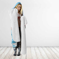 Sherpa hooded blanket with blue printed outer and open front, worn by woman
