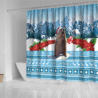 Blue Christmas shower curtain over bathtub, marmot in red hat, snowy mountains and poinsettias.