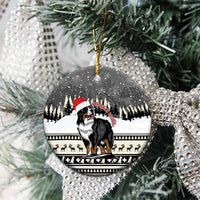 Ceramic round ornament close-up with Bernese mountain dog and snowy trees, gold hanging loop