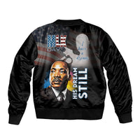 Black unisex bomber jacket with back print, portrait and His Dream Still text