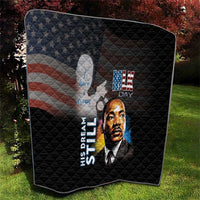 Black quilt on grass with quilted design, MLK Day portrait and stars-and-stripes