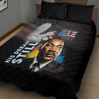 Black quilt bed set on bed with MLK portrait, stars, and 'His Dream Still' text.