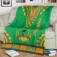 Green dashiki-pattern blanket on couch with V motif, star emblem, leaf edging and YOUR TEXT