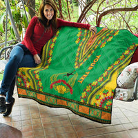 Green dashiki quilt held outdoors with “YOUR TEXT” and star motif, colorful border