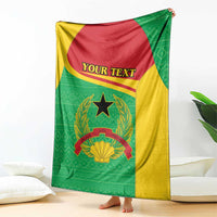 Personalized Guinea-Bissau blanket draped on sofa, green and yellow with coat of arms and “YOUR TEXT”