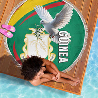 Round fringe beach blanket with Guinea coat of arms and white pigeon graphic, shown flat.