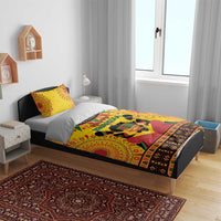 Orange African-pattern bedding set on bed with 'Happy Kwanzaa' candleholder design