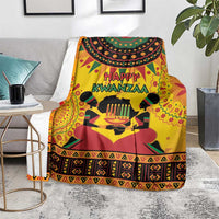 Orange Kwanzaa holiday blanket spread on floor with 'Happy Kwanzaa' text