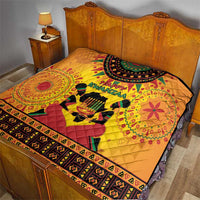 Orange Kwanzaa quilt on bed featuring Happy Kwanzaa text, drum graphic, patterned edge