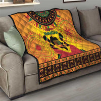 Orange Kwanzaa quilt draped over sofa with Happy Kwanzaa text, drum graphic, patterned trim