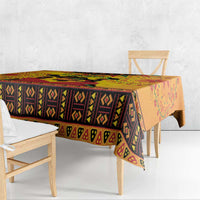 Orange Kwanzaa African-pattern tablecloth with diamond stripe band along the tabletop edge.