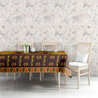 Orange African-pattern Kwanzaa tablecloth with repeating diamond and dot motifs on dining table.