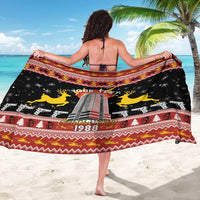 Black sarong with “OUR TEXT” and building print, yellow reindeer, red patterned border