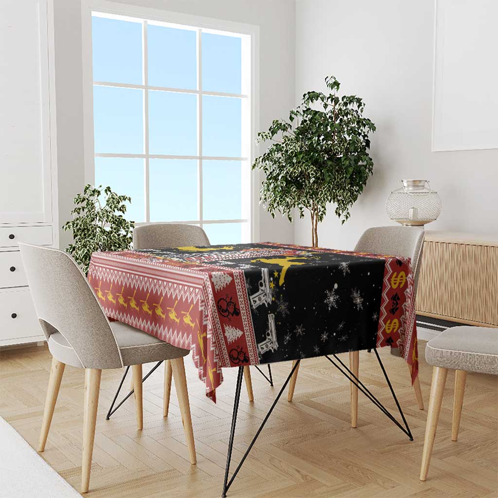 Black and red Christmas tablecloth with deer, houses, and geometric border on dining table