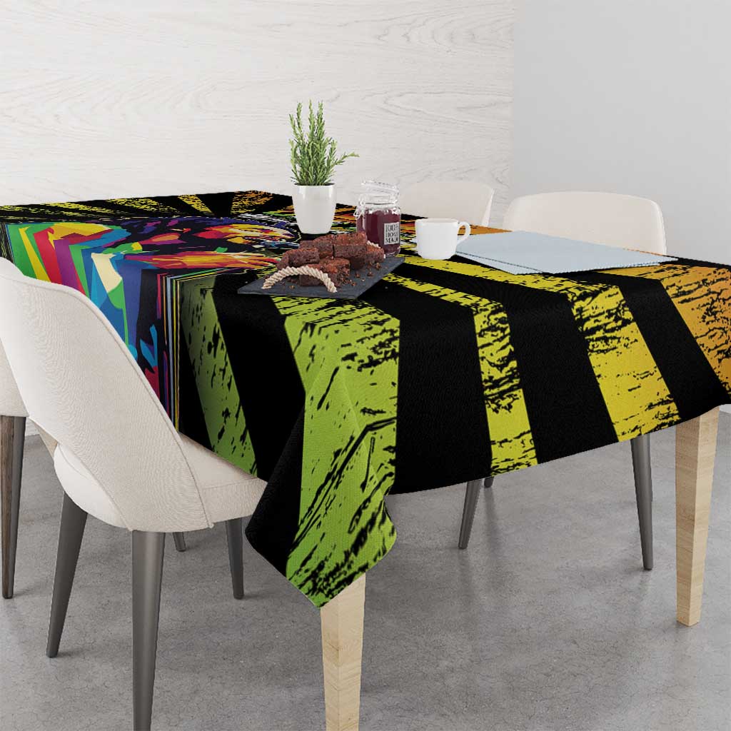 Dining table tablecloth with black, green, and bright geometric panels over light chairs
