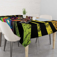 Dining table tablecloth with black, green, and bright geometric panels over light chairs